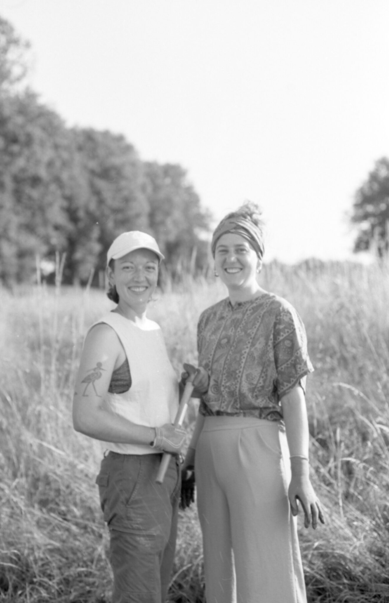 Pauline et Alice, cheffes d'exploitation de la Ferme ALPA, souriantes et au travail dans leurs champs, représentant leur engagement pour une agriculture durable et locale.