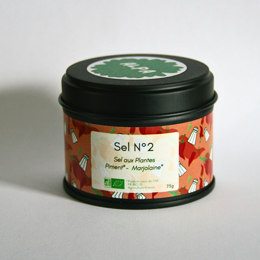 Pot en métal noir fermé contenant le sel aromatique au piment de Cayenne et à la marjolaine, placé sur un fond blanc épuré.